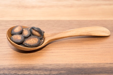 Watermelon seeds in spoons on wood backgroundsの写真素材