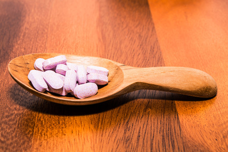 Vitamins capsule in a spoon