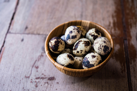 Quail eggs in wooden bowl on wood backgroundsの写真素材