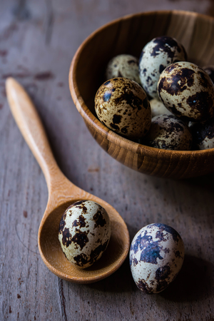 Quail eggs in wooden bowl on wood backgroundsの写真素材