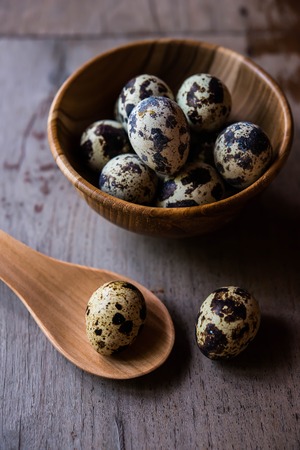 Quail eggs in wooden bowl on wood backgroundsの写真素材
