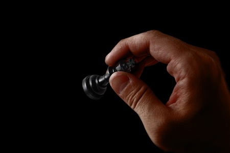 Man's hand holding chess