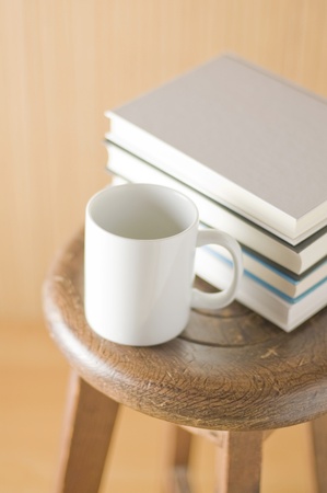 Wooden wall with old chair and books and cupの写真素材