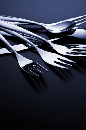 the metal shiny spoon and fork on black backgroundの写真素材