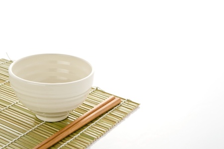 Rice bowl and chopstick on bamboo matの写真素材