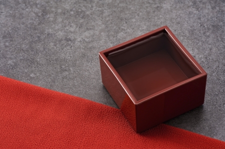 Sake in square cup on stone background, close-up の写真素材