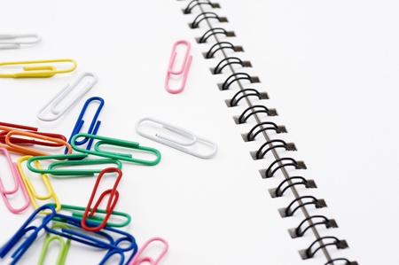 Colorful paper clip on white sketchbook, close-up 