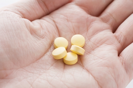 Medical tablets on male hand, close-up shoot の写真素材