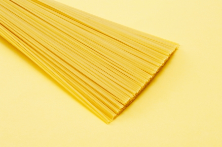spaghettis pasta on yellow background, close-up shoot 