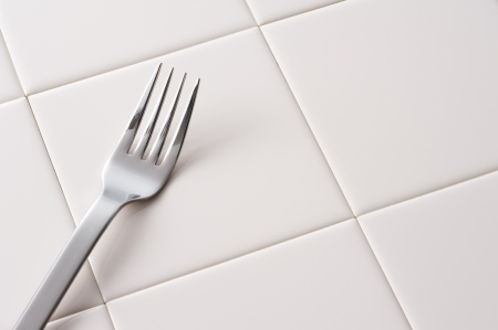 Silver spoon on tile floor background, close-up の写真素材