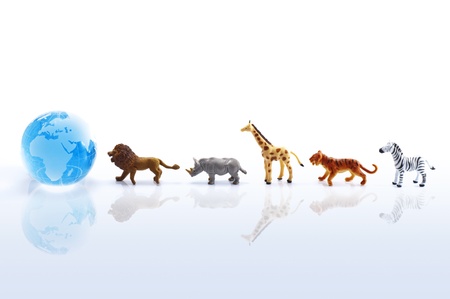 Animal toys and clear glass globe on white background の写真素材