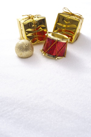 Gift box and drum christmas ornaments on snow background の写真素材