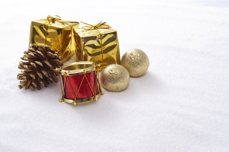 Gift box and drum christmas ornaments on snow background の写真素材