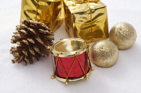 Gift box and drum christmas ornaments on snow background の写真素材