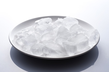 Ice cubes on a dish, white background の写真素材