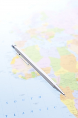 a silver pencil on world map backgroundの写真素材
