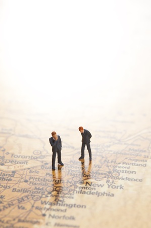 miniature businessman figurines on world map backgroundの写真素材