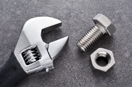 monkey wrench and bolt and nut on stone background, close-up の写真素材