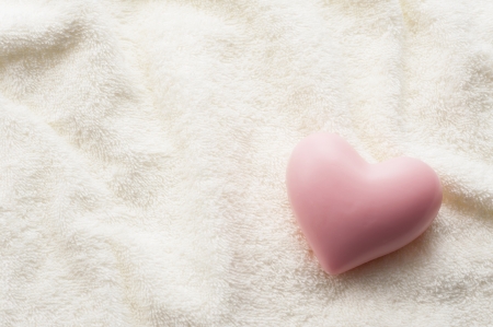 Heart-shaped soap on towel fabric backgroundの写真素材