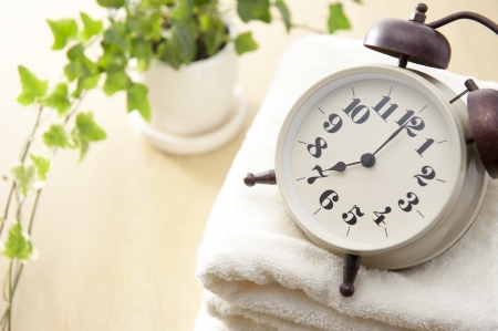 Traditional mechanical alarm clock on towelの写真素材