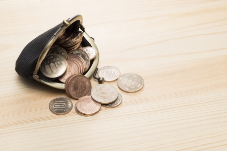 black purse with coins on wooden backgroundの写真素材