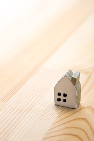 Miniature brick house on wooden floorの写真素材