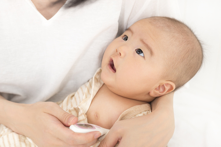 Measure the baby's body temperature with a thermometerの写真素材