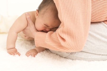 Mother holding a crying babyの写真素材
