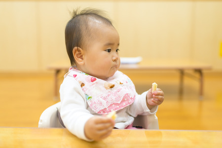 Baby eating snacksの写真素材