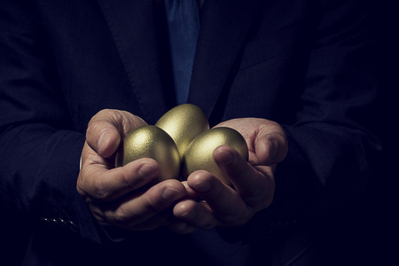 Businessman holding golden egg.の写真素材