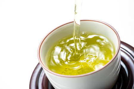 Pouring green tea,  on white backgroundの写真素材
