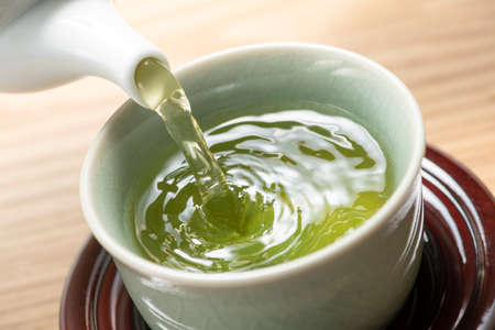 Pouring green tea on tableの写真素材
