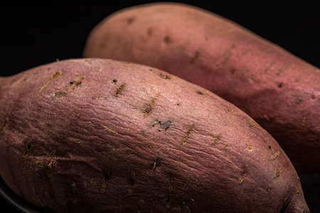 Hot baked sweet potates, on black backgroundの写真素材