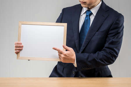 Businessman holding a whiteboard in hand.の写真素材