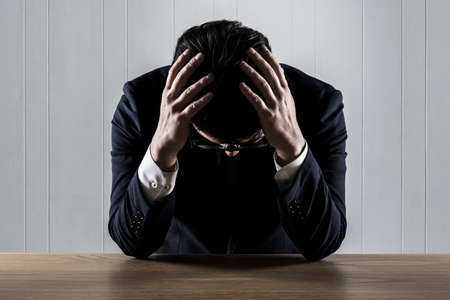 Businessman holding his head in trouble.の写真素材