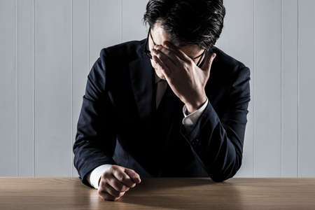 Businessman holding his head in trouble.の写真素材