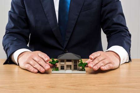 Businessman and house model on table.の写真素材