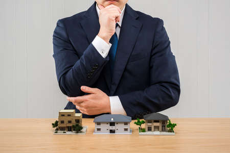 Businessman and house model on table.の写真素材
