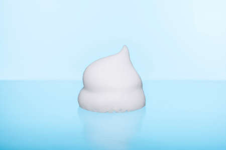 Foam on a blue background, face washing form.