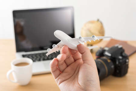 Laptop and airplane model, travel planning.の写真素材