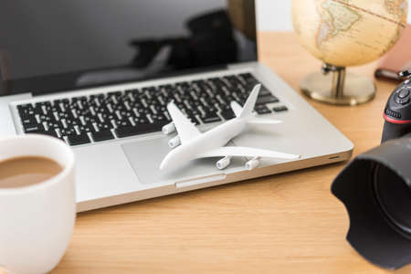 Laptop and airplane model, travel planning.の写真素材