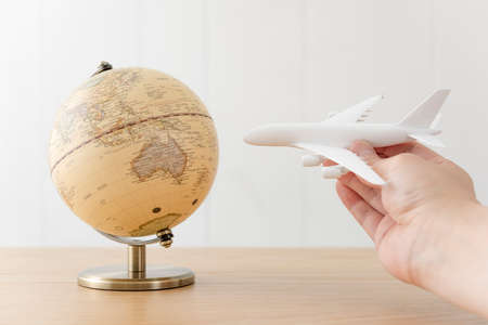 Airplane model and globe on wooden desk.の写真素材
