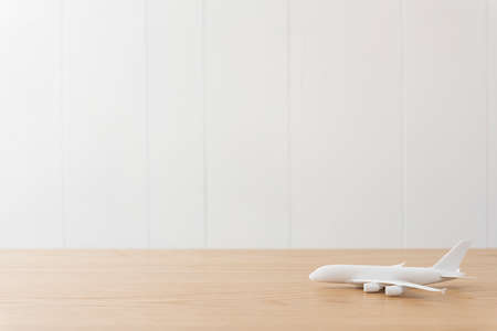 On the wooden desk is the runway of the model airplane.の写真素材