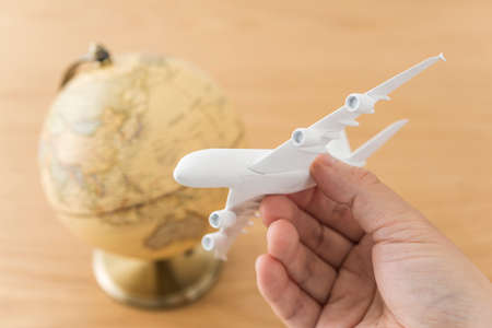 Airplane model and globe on wooden desk.