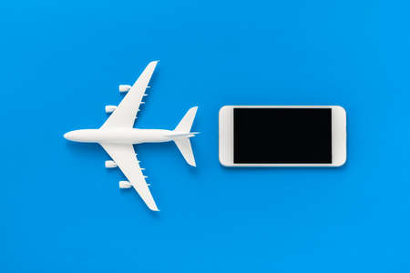 Airplane model and smartphone on blue background.の写真素材