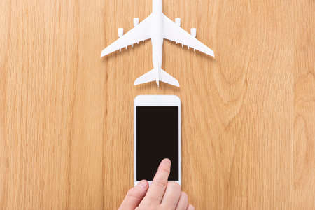Airplane model and smartphoneãon wooden table.の写真素材