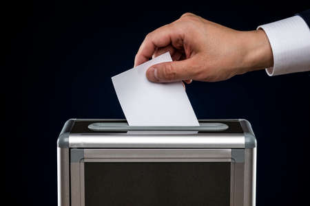 Man to voting wearing a suit.