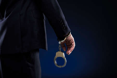 Handcuffed men, wearing a suit.の写真素材