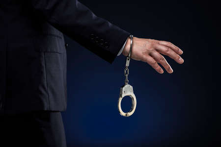 Handcuffed men, wearing a suit.の写真素材