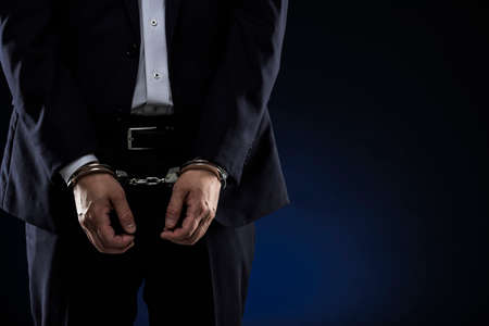 Handcuffed men, wearing a suit.の写真素材